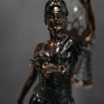 Detailed bronze statue of Lady Justice with scales, symbolizing law and justice.